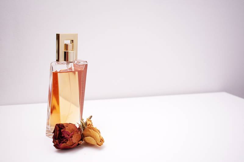 Frasco de perfume com rosa seca na frente