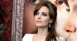 Angelina Jolie eleva su elegancia en un vestido blanco de escote con volante, cinturón de oro y falda lápiz