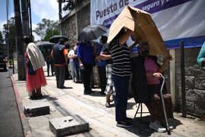 Esperando bajo el sol, guatemaltecos hacen fila para recibir la vacuna