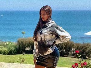 Khloé Kardashian sorprende en un abrigo de piel rosa y botas hasta la rodilla