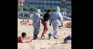 Surfista com covid-19 é retirada da praia por agentes com roupa anticontaminação