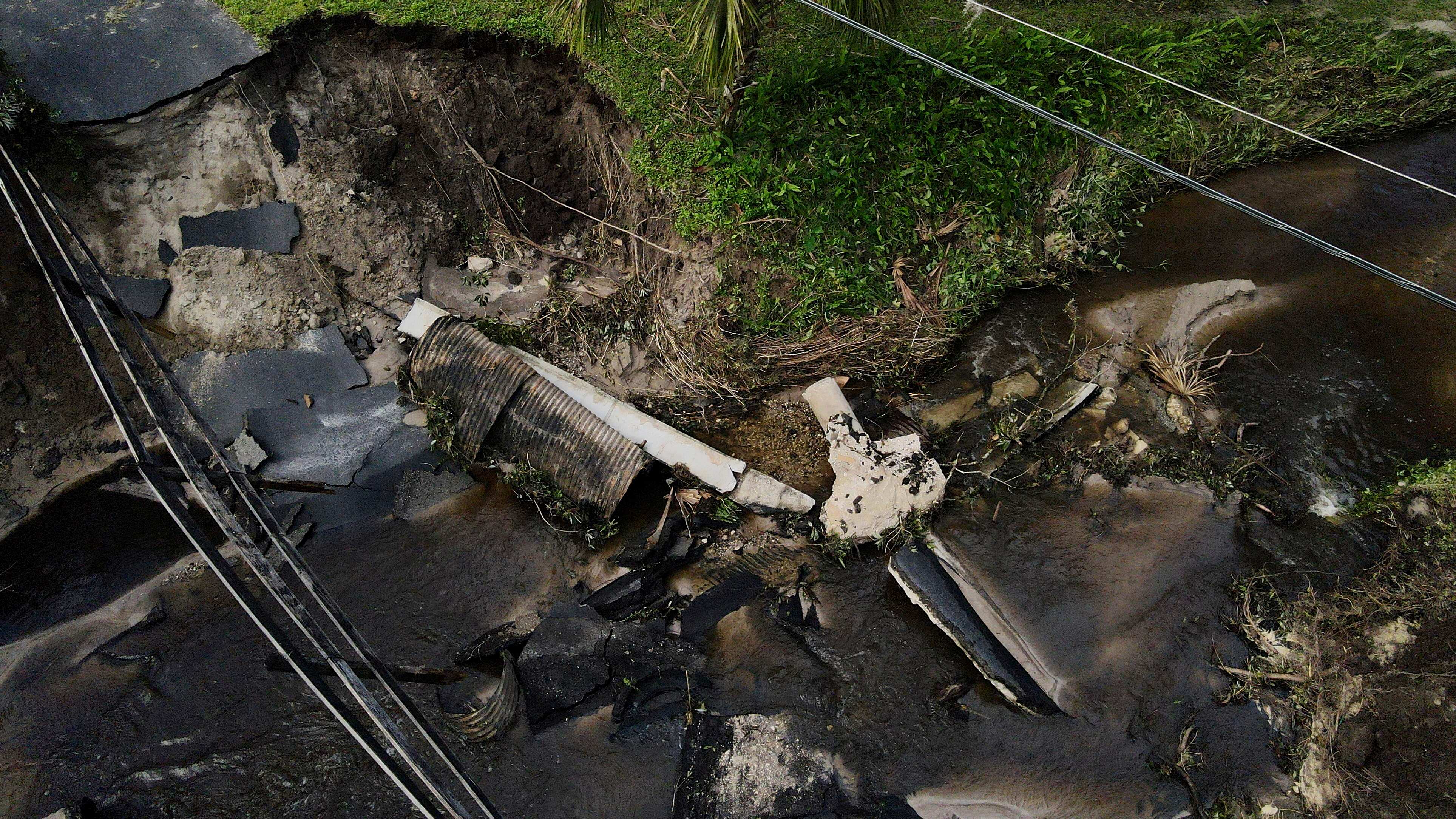 Del Ockey, un canadiense que vive en Florida durante los seis meses más fríos del año, camina cerca de un puente dañado que va hacia su propiedad, en Riverview, Florida, el viernes 11 de octubre de 2024, tras el paso del huracán Milton. (AP Foto/Julio Cortez)