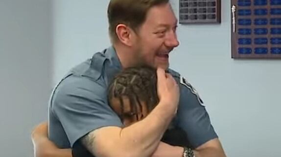 El detective abraza al niño al que salvó hace varios años