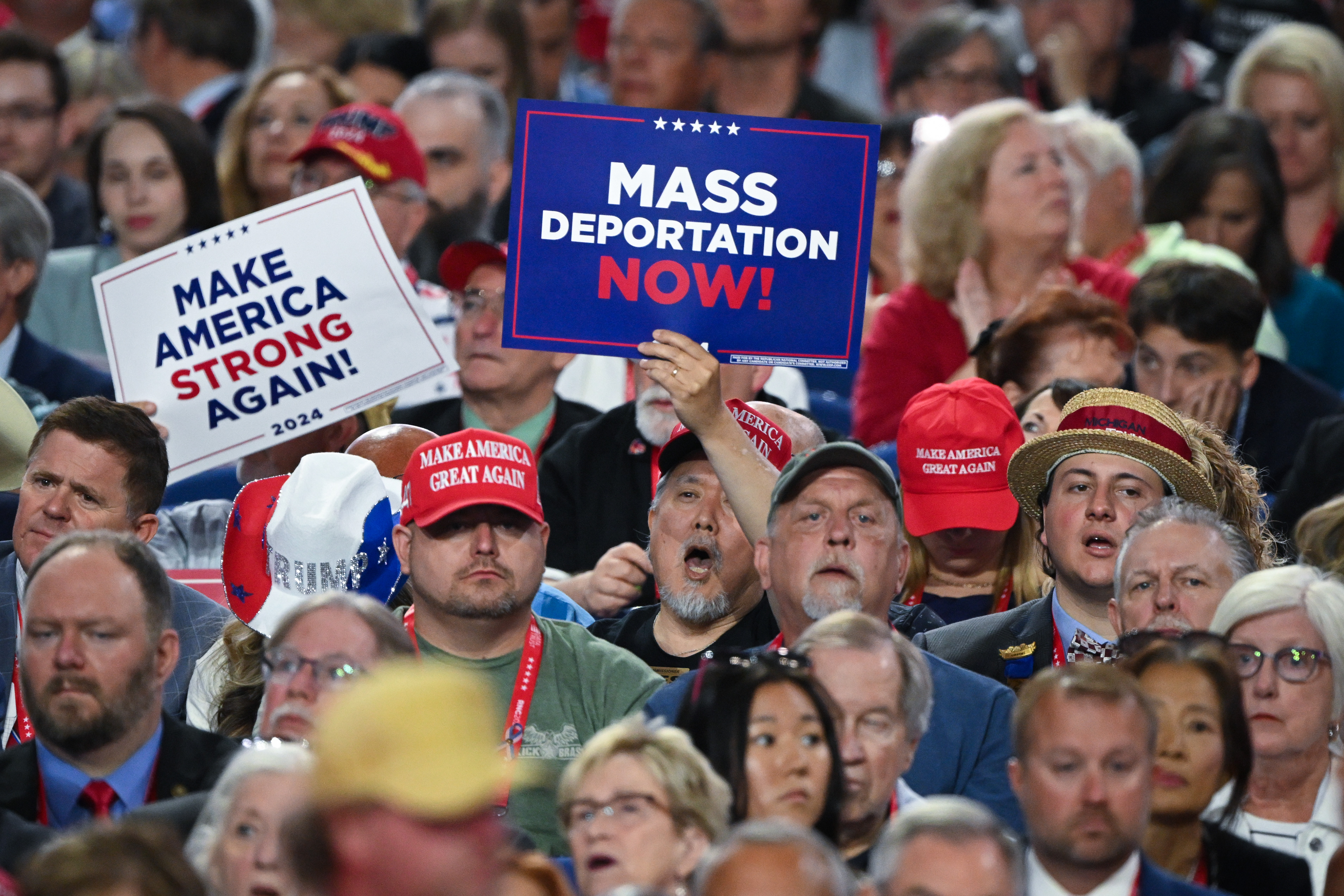 Una persona sostiene un cartel que dice "Deportación masiva ahora" en la Convención Nacional Republicana en julio de 2024 en Milwaukee, Wisconsin.