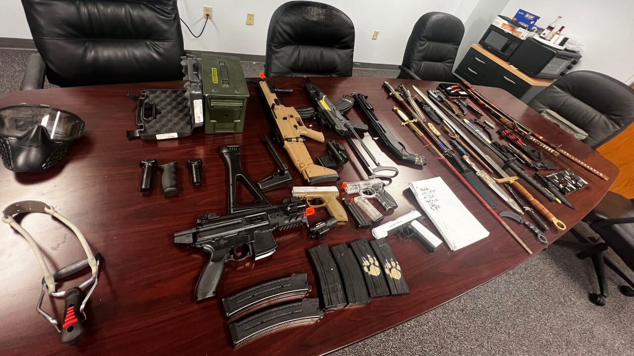 Niño con arsenal de armas.