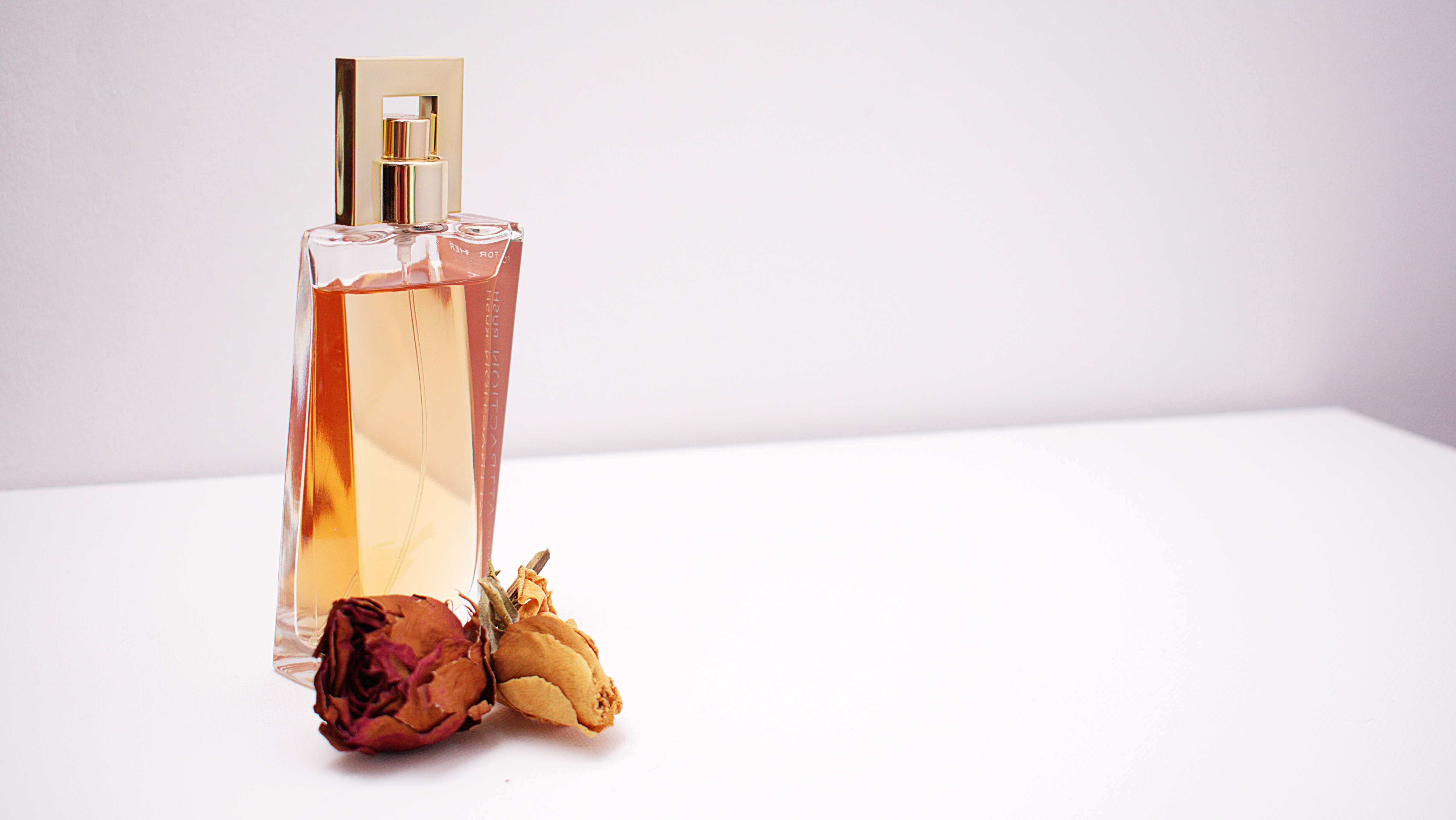 Frasco de perfume com rosa seca na frente