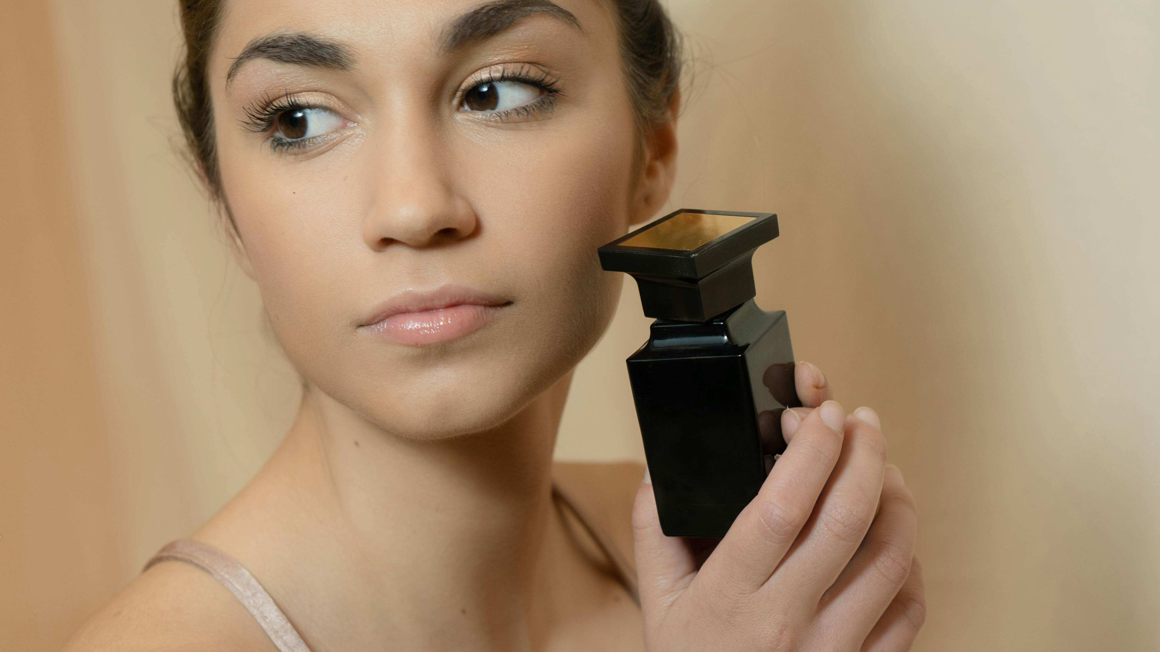 Mulher com frasco de perfume preto