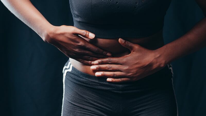 Mulher apertando a própria barriga