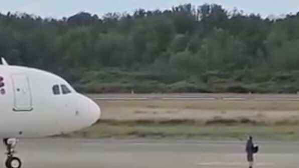 Hombre se interpone frente a un avión